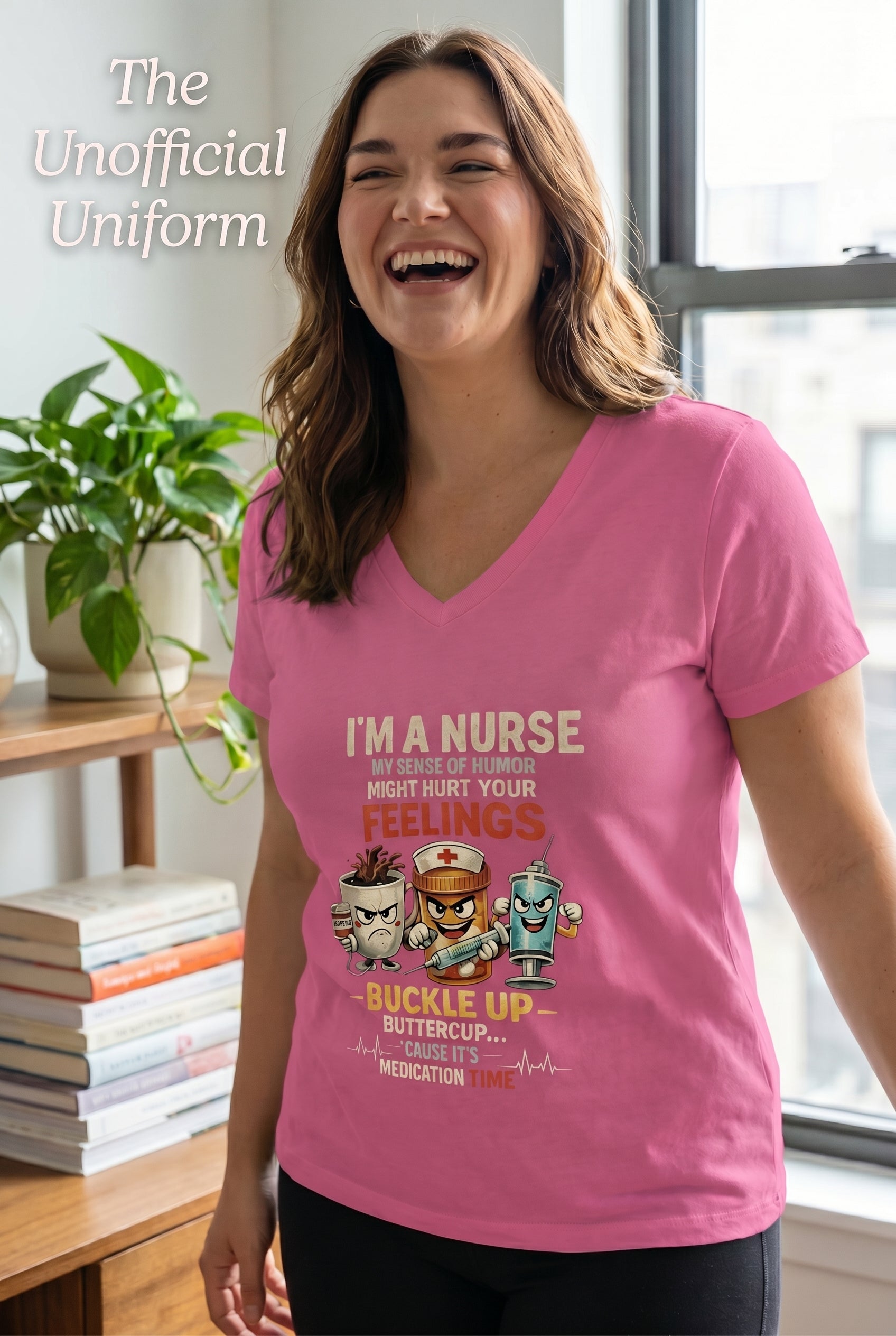 Woman wearing a pink nurse-themed graphic t-shirt featuring healthcare characters and the phrase "I'm a Nurse, My Sense of Humor Might Hurt Your Feelings. Buckle Up Buttercup, It's Medication Time."