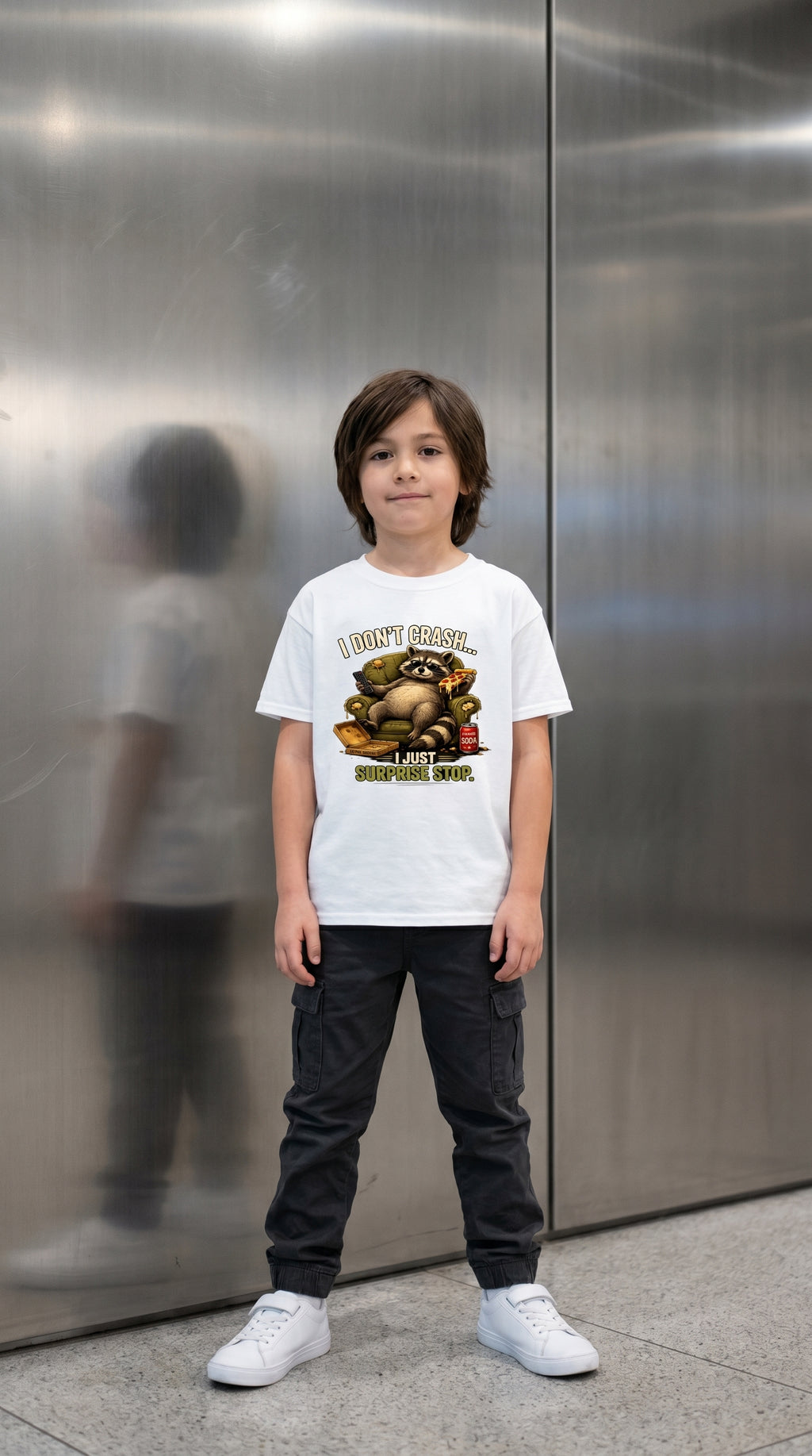 Child wearing T-shirt featuring a funny Raccoon graphic and the phrase "I don't Crash, I just Surprise Stop."